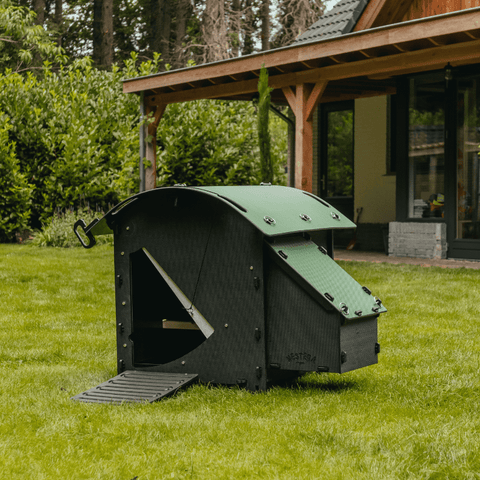 Sfeerfoto Nestera kunststof kippenhok klein, schuin vooraanzicht in een achtertuin op het gras.