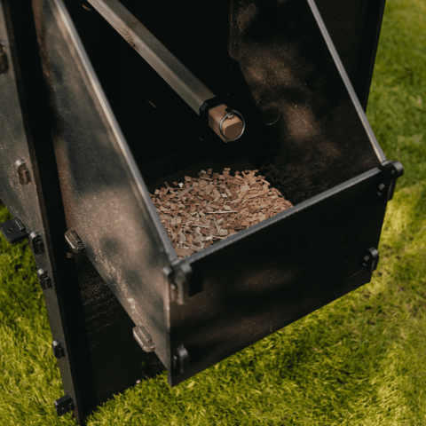 Sfeerfoto Nestera kunststof kippenhok klein op wielen, schuin zijaanzicht en ingezoomd op het zijcompartiment. Het dak van het zijcompartiment is verwijderd en in het compartiment liggen houtsnippers.