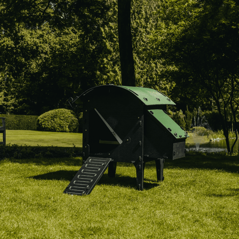 Sfeerfoto Nestera kunststof kippenhok klein, schuin vooraanzicht in een achtertuin op het gras.